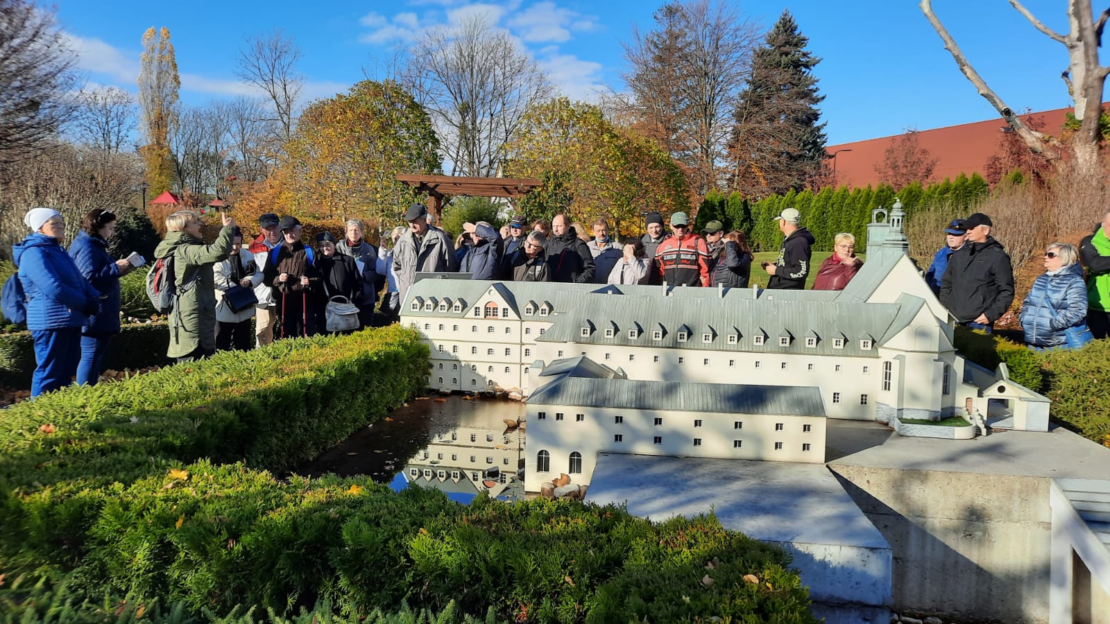 Grupa osób głuchych ogląda miniaturę obiektu sakralnego w Parku Miniatur w Olszowej.
