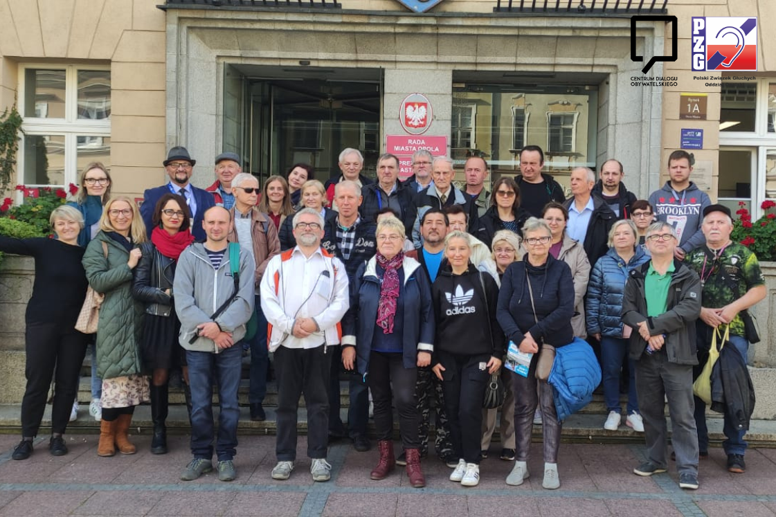 Zdjęcie grupy osób głuchych oraz towarzyszących podczas obchodów Dnia Osób Głuchych w Opolu.